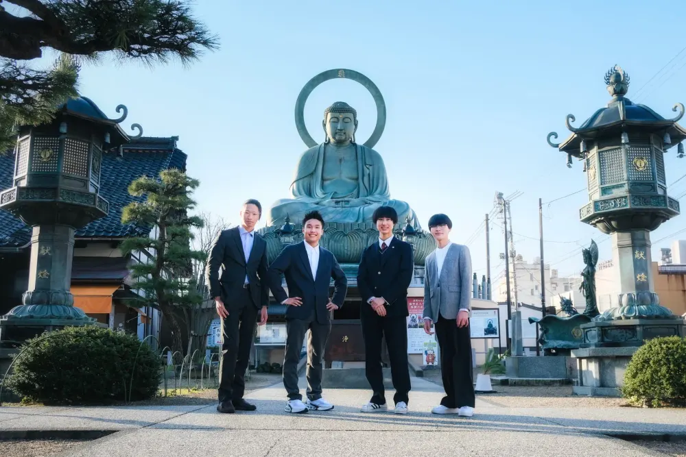 高岡大仏の前に立つ学生団体takaokaのメンバー